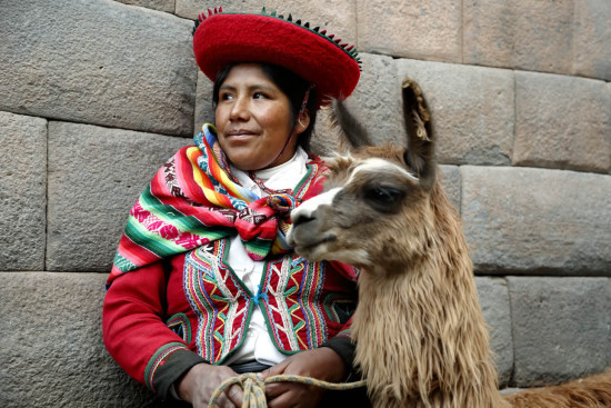 Quechua woman (Viviana), llama and Inca walls, Cusco, Peru