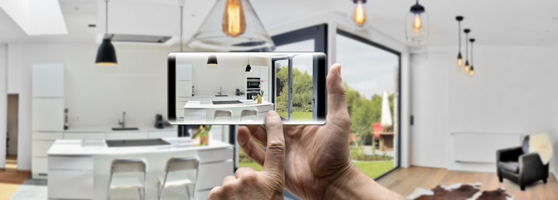 Two hands holding a mobile Smartphone and take a picture in a Modern luxury living room and kitchen